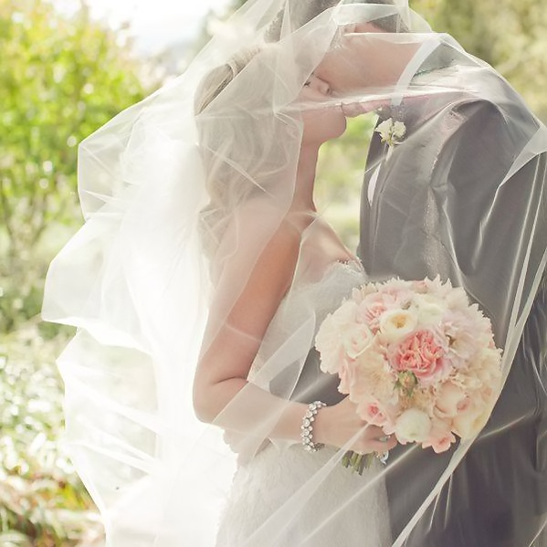 bride and groom kissing under veil