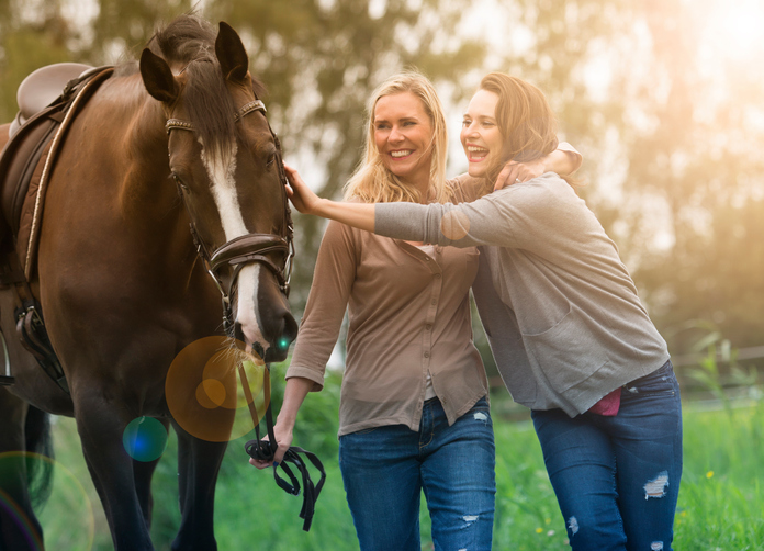 two woman and horse at a farm
