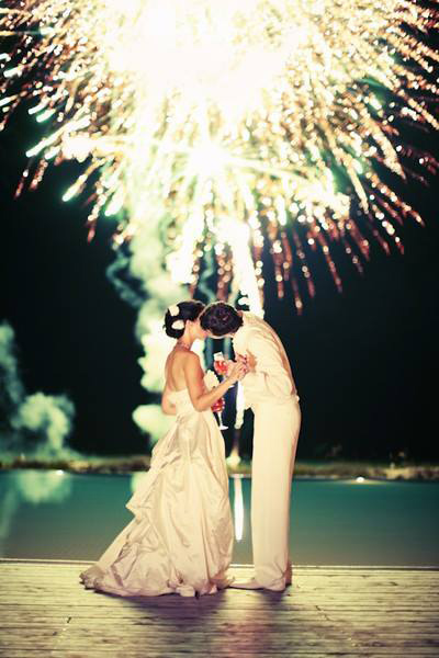 wedding couple kisses under fireworks at 4th july